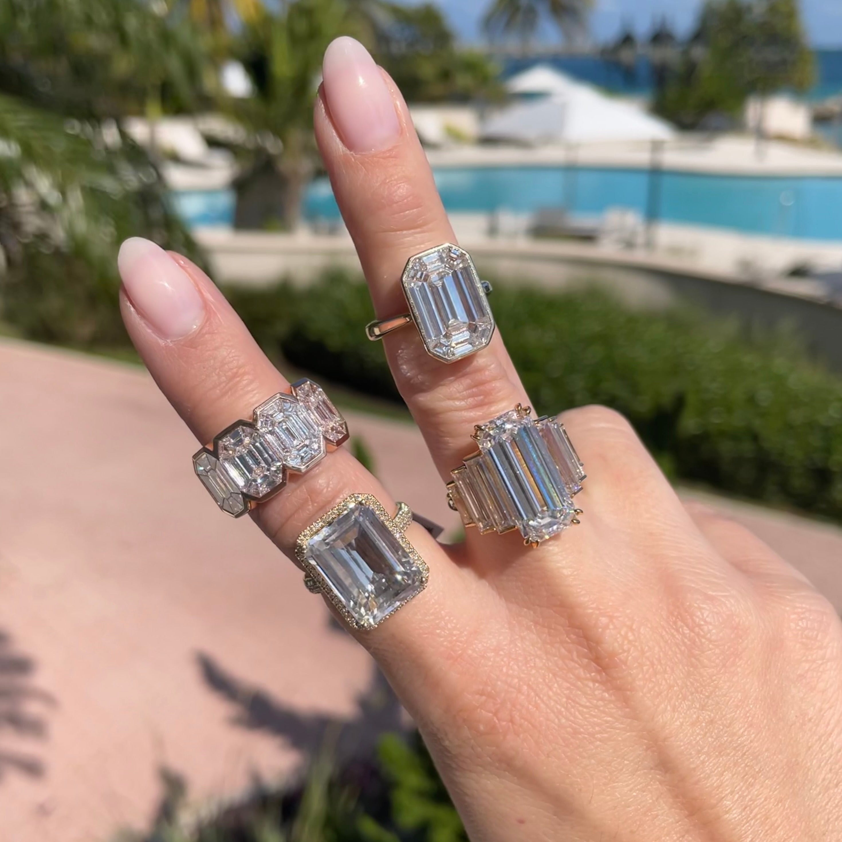 Woman wearing diamond emerald cut rings.