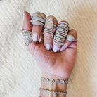 Diamond pinky ring worn with diamond pave statement rings and white gold pave bracelets