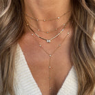 Woman wearing layered yellow gold diamond necklaces.