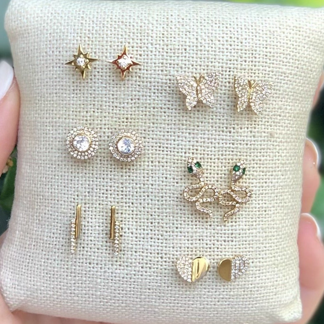 Diamond double earrings on display pillow with yellow gold and diamond stud collection