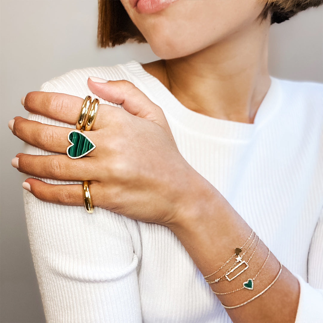 Diamond & malachite heart bracelet worn with yellow gold thin bracelets and large chunky rings