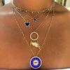 Lapis & diamond star necklace layered with other yellow gold & lapis necklaces on woman's neck