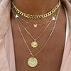 Cuban link chain layered with delicate yellow gold necklaces