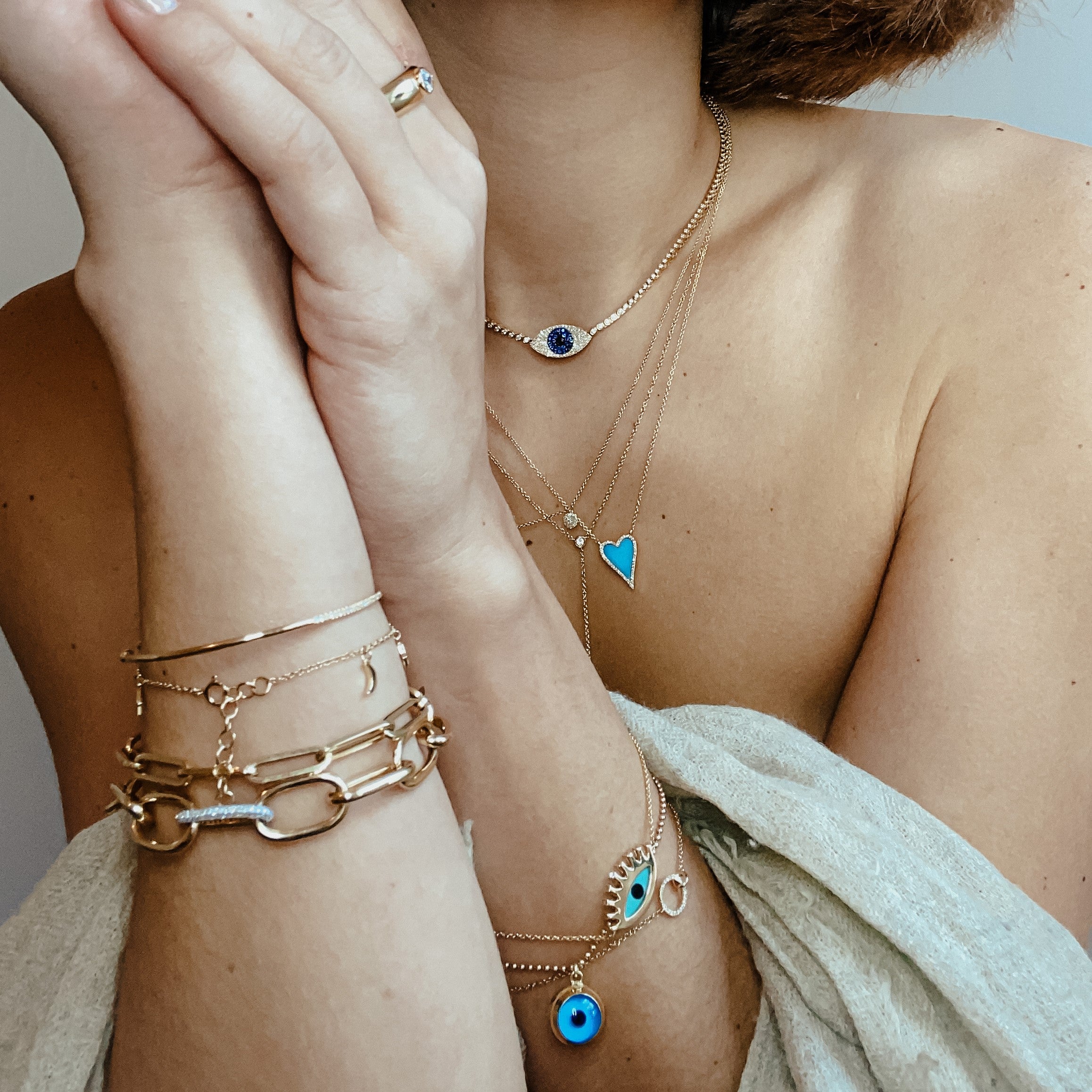 Turquoise & Diamond heart necklace worn layered with yellow gold necklaces and chain link bracelets