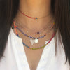 Woman wearing evil eye choker with layered colorful necklaces