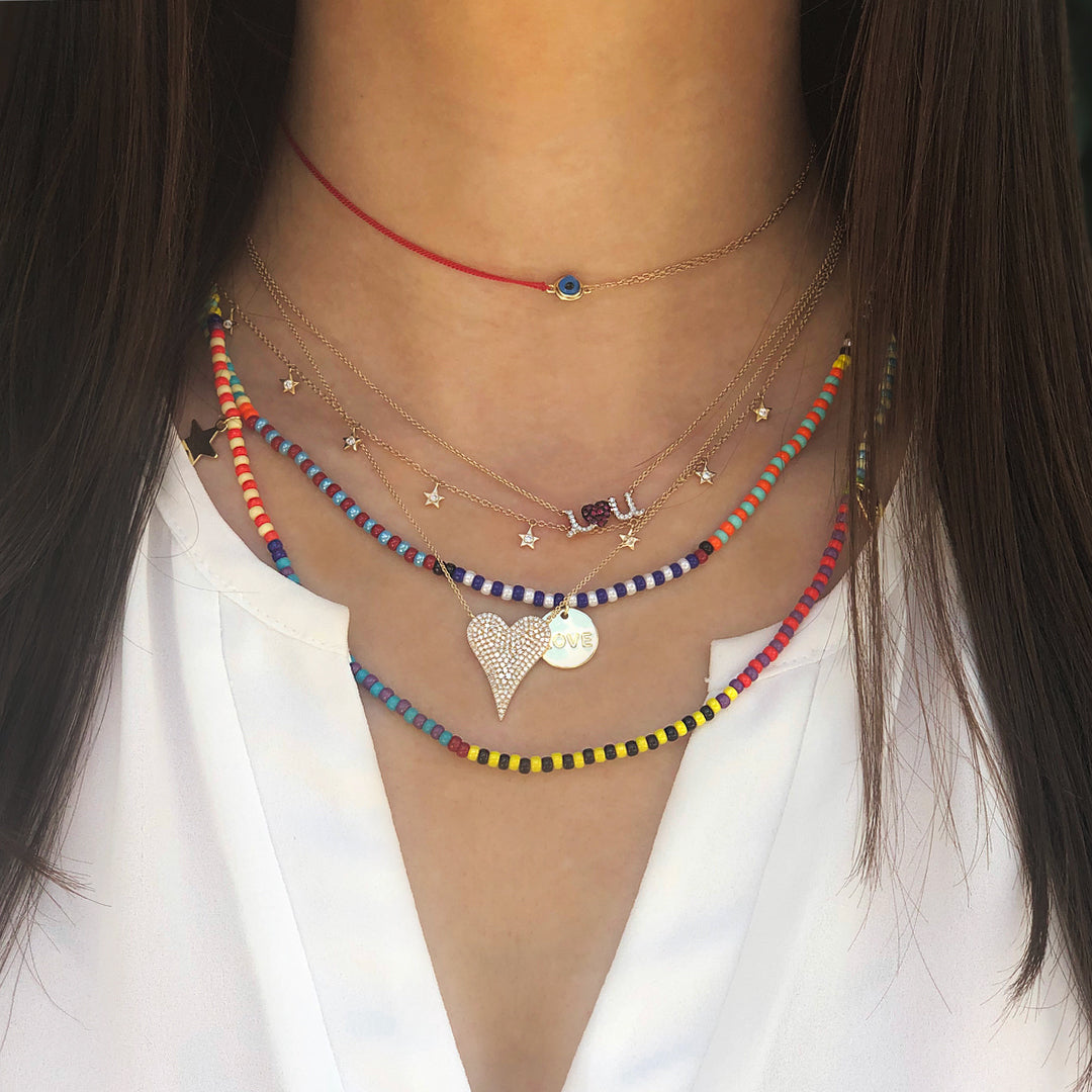 Woman wearing evil eye choker with layered colorful necklaces