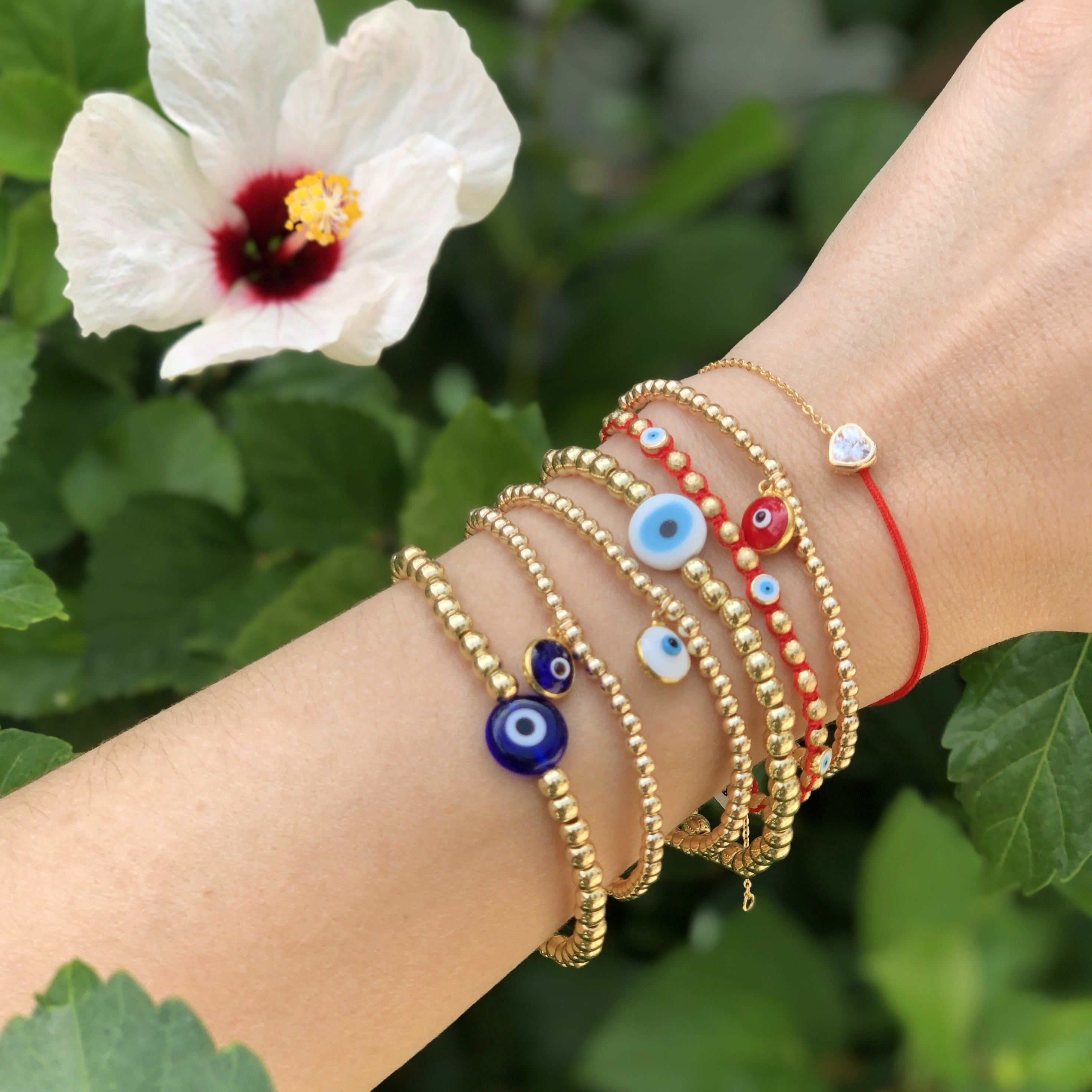 Cord + chain bracelet layered with yellow gold beaded bracelets