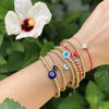 Evil eye bracelets displayed on woman's wrist in varying colors and sizes