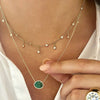 Diamond choker necklace worn with emerald on yellow gold chain