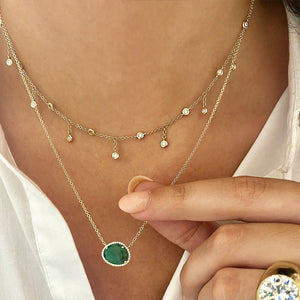 Diamond choker necklace worn with emerald on yellow gold chain