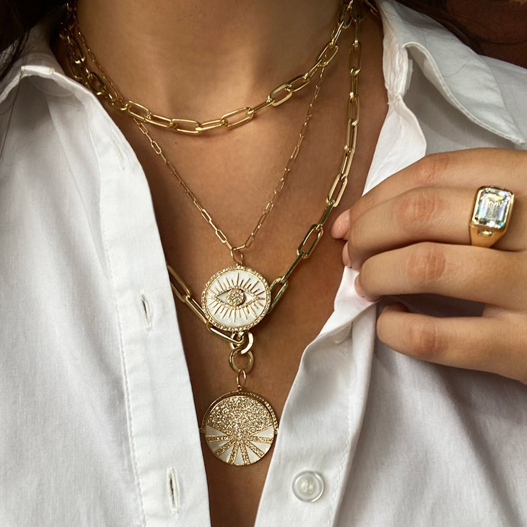 Emerald cut ring modelled with yellow gold chain link necklaces