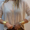 Woman wearing open 3 band cuff with yellow gold bangle bracelets and anchor link lariat necklace