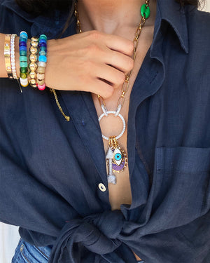 CZ tennis bracelet modelled with rainbow beaded bracelets and statement charm necklace