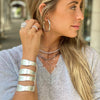 Girl wearing cut out cuff with other white gold jewelry from collection