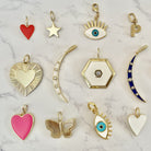 Yellow gold charm collection against a white marbled background