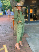 Jennifer Miller wearing long sleeve jumpsuit with gold wrap wrist watch