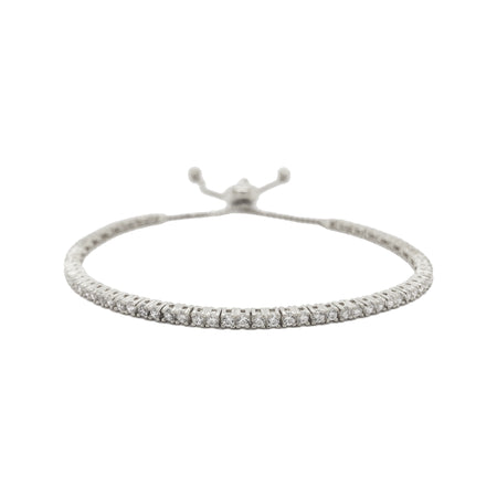 Pave Tennis Bracelet  The tennis bracelet-a classic through the years, updated with a bolo closure.  Prong set CZs over Vermeil.  Simple, Stated, Elegant.  White Gold Plating Over Silver Prong set Cubic Zirconia 0.7" Wide Adjustable to Fit Most Wrists