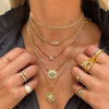 Yellow gold ring and chain necklace collection on woman, including diamond pave nail ring