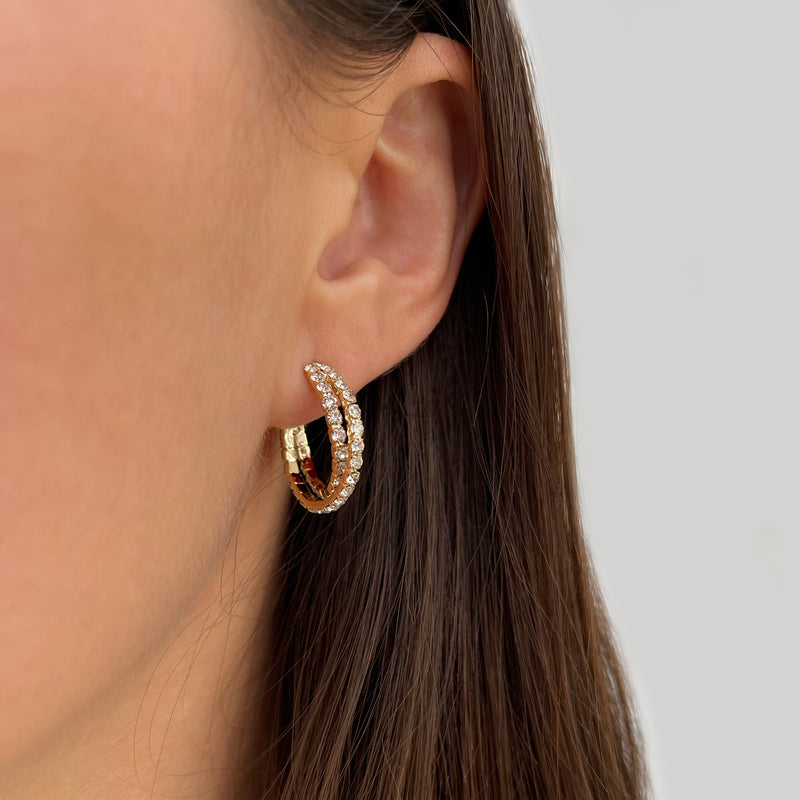 Yellow gold bypass hoop earring on woman's ear