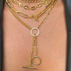 Layered chunky chain yellow gold necklaces on a model's neck.