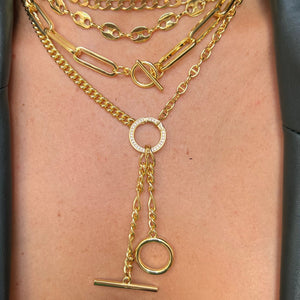 Layered chunky chain yellow gold necklaces on a model's neck.