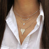 Diamond small necklace in white gold layered with other white gold chains on a woman's neck