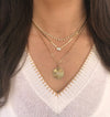 Diamond gradual necklace layered with other yellow gold diamond chains on woman's neck