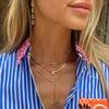 Woman wearing diamond lariat necklace with shorter yellow gold necklaces & diamond link drop earrings