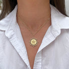 Woman wearing a star medallion necklace.