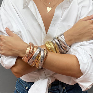 Woman wearing layered triple strand bracelets in yellow, white, and rose gold