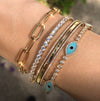 Oval link bracelet worn on wrist with teal and diamond bangle bracelets