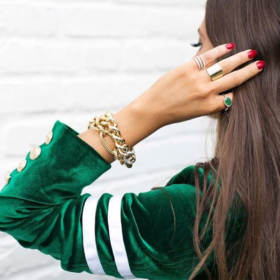 Woman wearing diamond coil ring with chunky yellow gold bracelets
