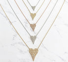 Pave diamond necklaces in rose, white, and yellow gold; and small, medium, and large sizes against a marbled background