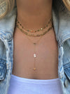 Three yellow gold necklaces on a neck.