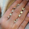 Diamond XO studs displayed between womans fingers with others from yellow gold stud collection