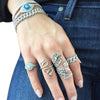 Woman wearing leaf ring with white gold rings and pave bracelets