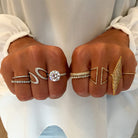 White and yellow gold assortment of rings on woman's hands, including diamond eternity band