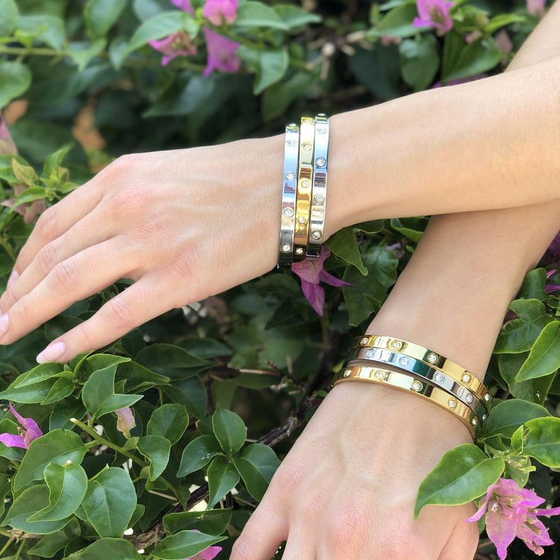 Woman wearing yellow and white gold eternity bracelets on each wrist