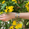 Woman wearing yellow and white gold crystal eternity bangles