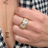 Gypsy ring on woman's finger paired with yellow gold lariat necklace