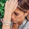 Diamond link bracelet in white gold on woman's wrist with others from white gold collection